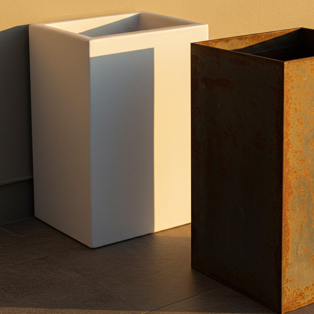 Fiberglass Planters Versus Other Planter Materials 5 Side-by-side view of a smooth white fiberglass planter and a weathered metal planter with rust patina, highlighting the contrast between sleek modern finish and industrial aged texture.