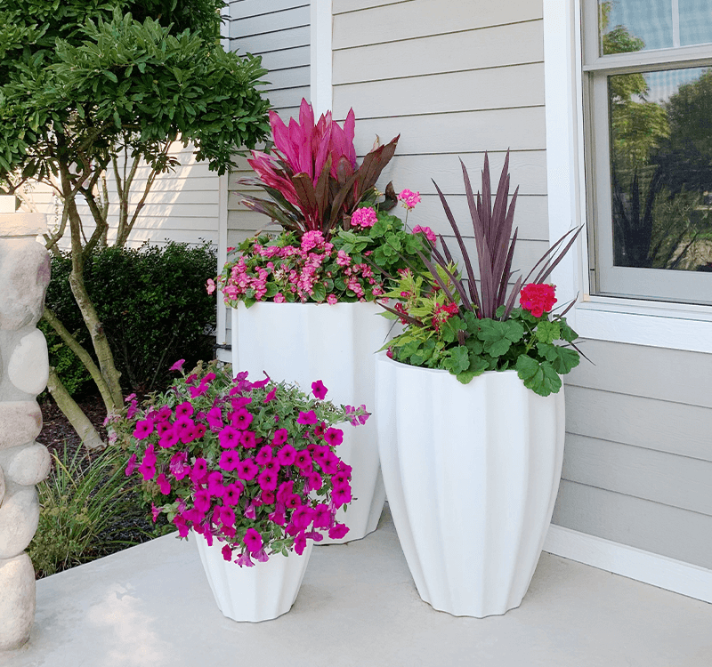 A collection of stylish, modern fiberglass planters in various shapes and colors.